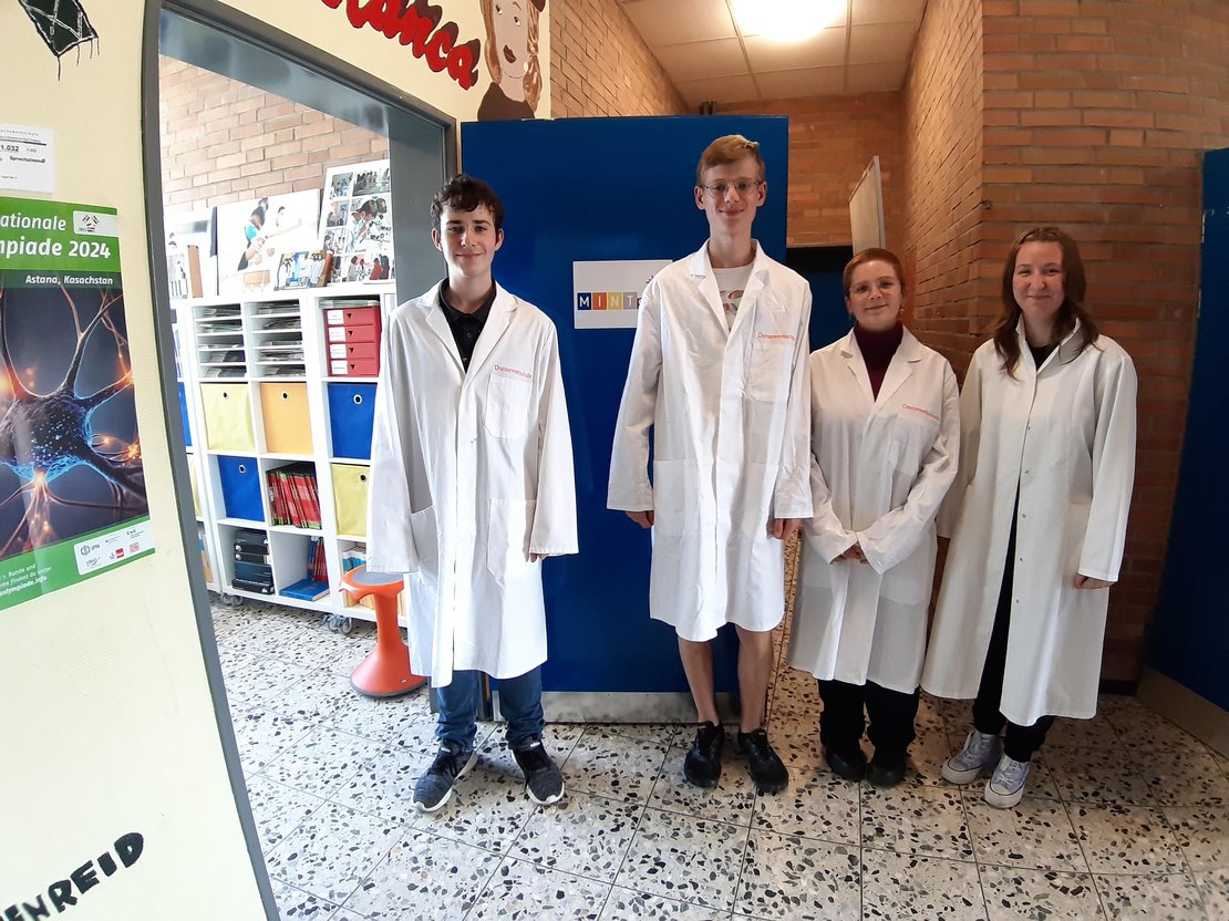 Foto Schüler*innen im Laborkittel vor MINT-Raum
