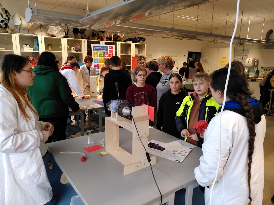 Foto Schüler*innen an Experimentaufbau