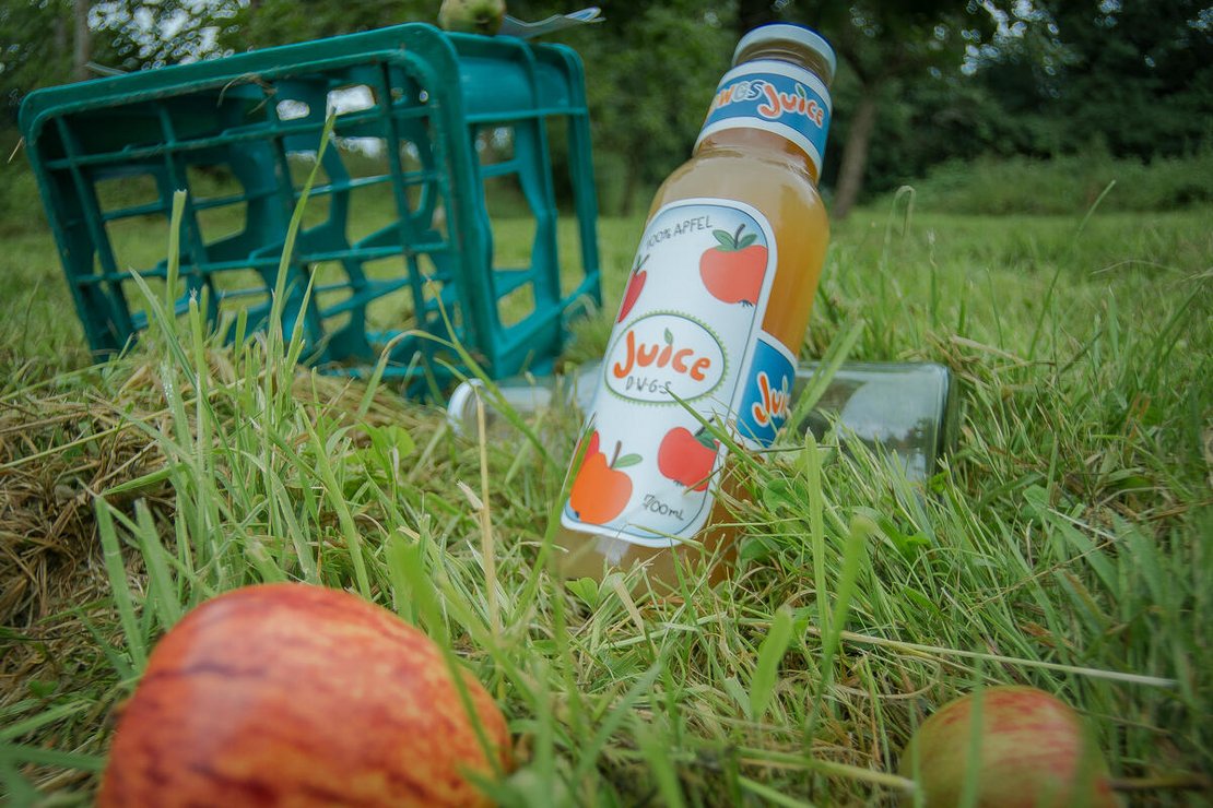 Gartenbild mit einer Flasche selbst hergestellten Apfelsaft
