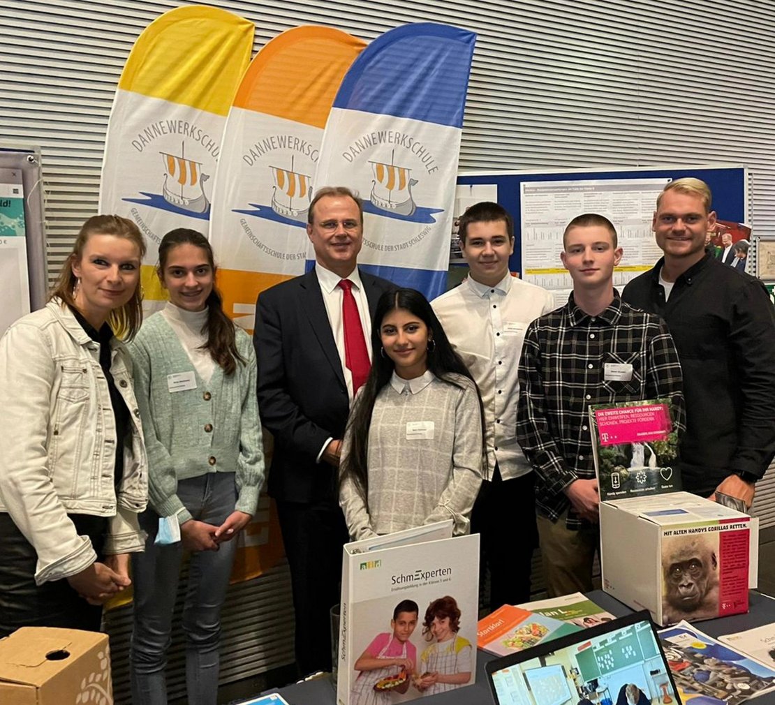 Pressefoto einer Gruppe Schüler*innen mit Minister Clausen in Berlin.