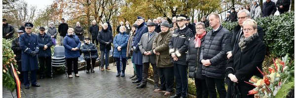 Foto mehrere Personen stehen im Halbkreis am Volkstrauertag