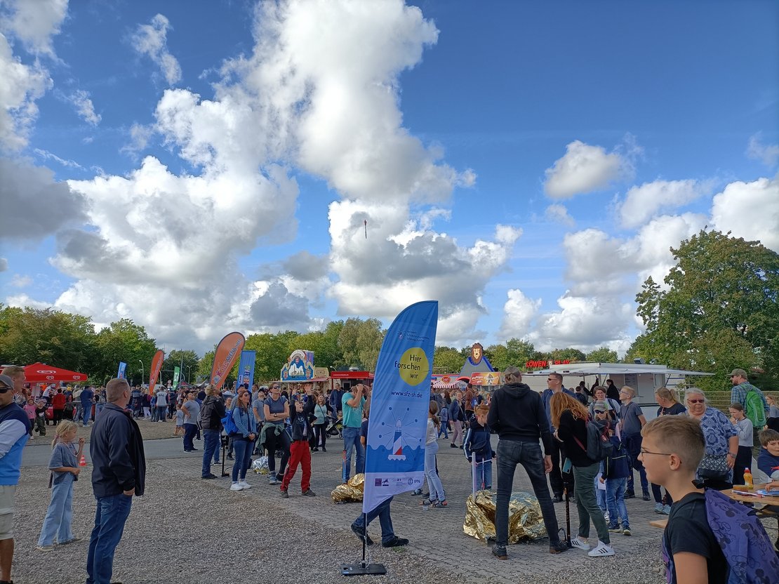Foto Ausschnitt vom RSH Kindertag mit dem Aufsteller des Schülerforschungszentrums.